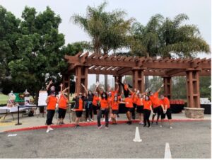 A group of people in orange shirts standing next to each other.