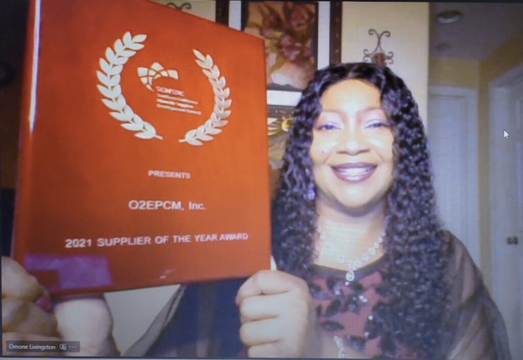 A woman holding up a red certificate inside a room