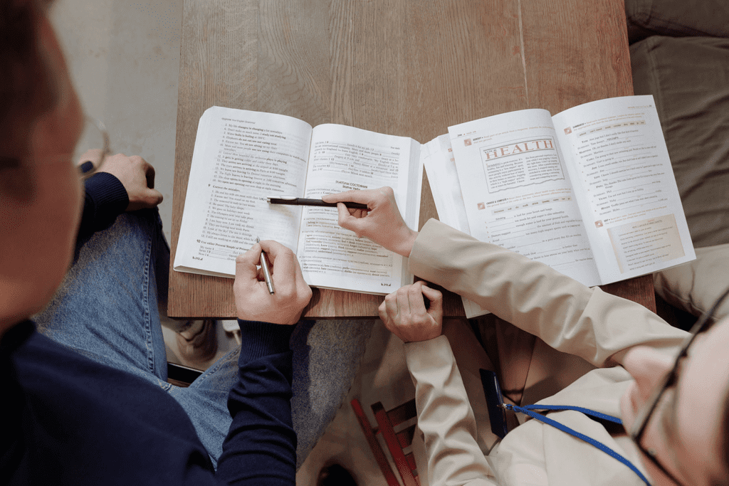 A group of people sitting at a table with books.