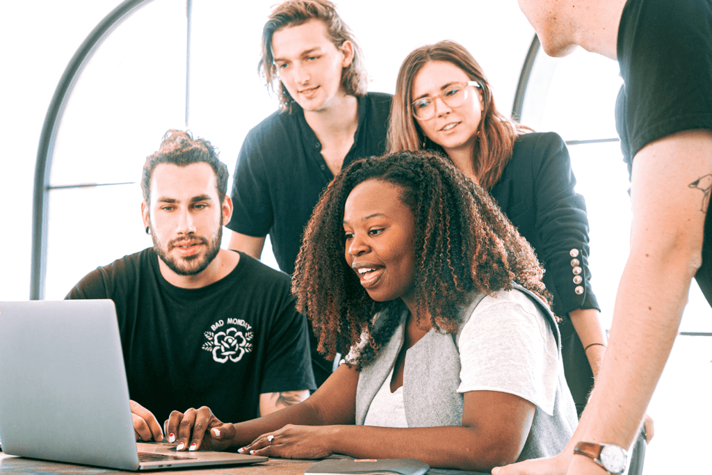 A group of people gathered around a laptop.